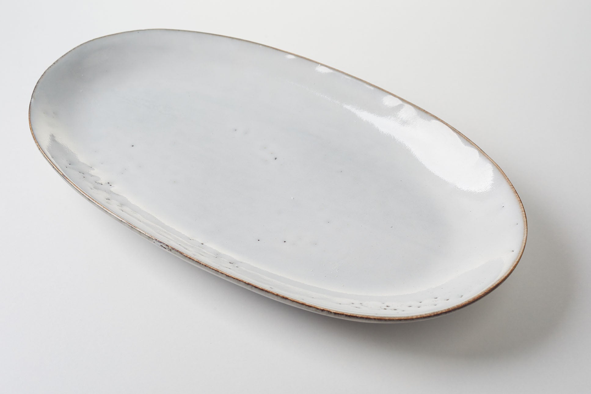 Oval platter with white glaze and brown rim